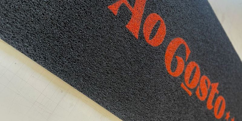 Imagem de capachos personalizados da franquia de carnes Ao Gosto, destacando identidade visual e qualidade.

