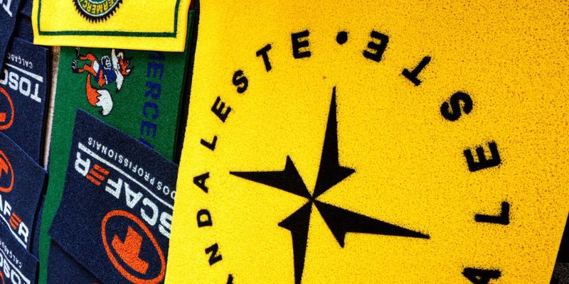 Imagem de um tapete amarelo com logomarca de empresa, usado para destacar a identidade visual em ambientes corporativos.